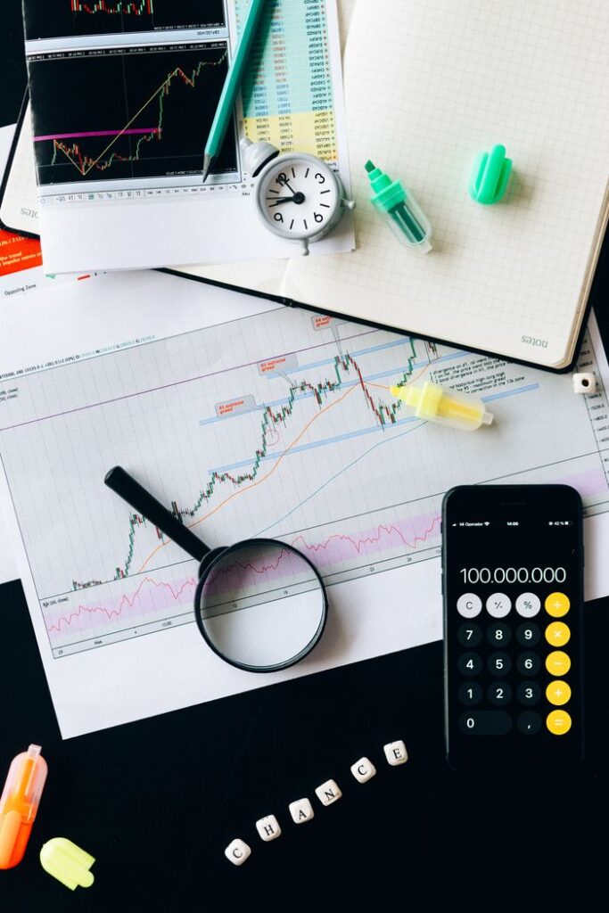 pexels-photo-6120208-6120208 Stock market analysis setup with graphs, calculator, and magnifying glass.