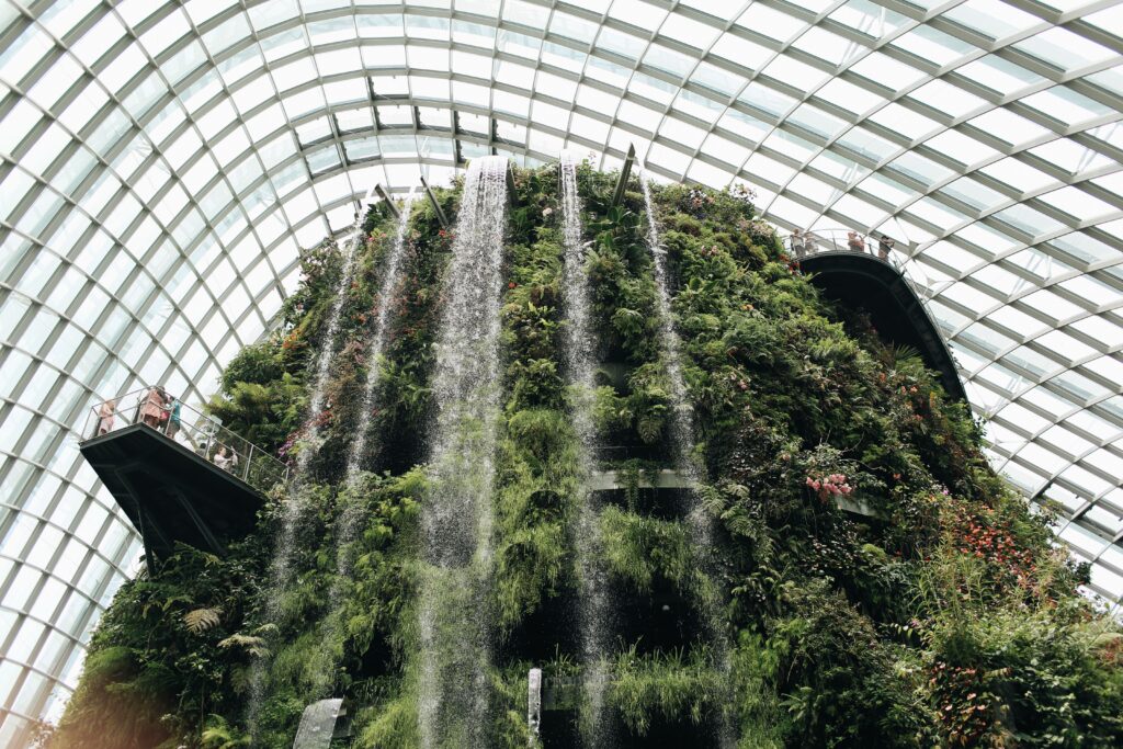 zipwp-image-4239725 Breathtaking indoor waterfall amidst lush greenery at Singapore's Gardens by the Bay.